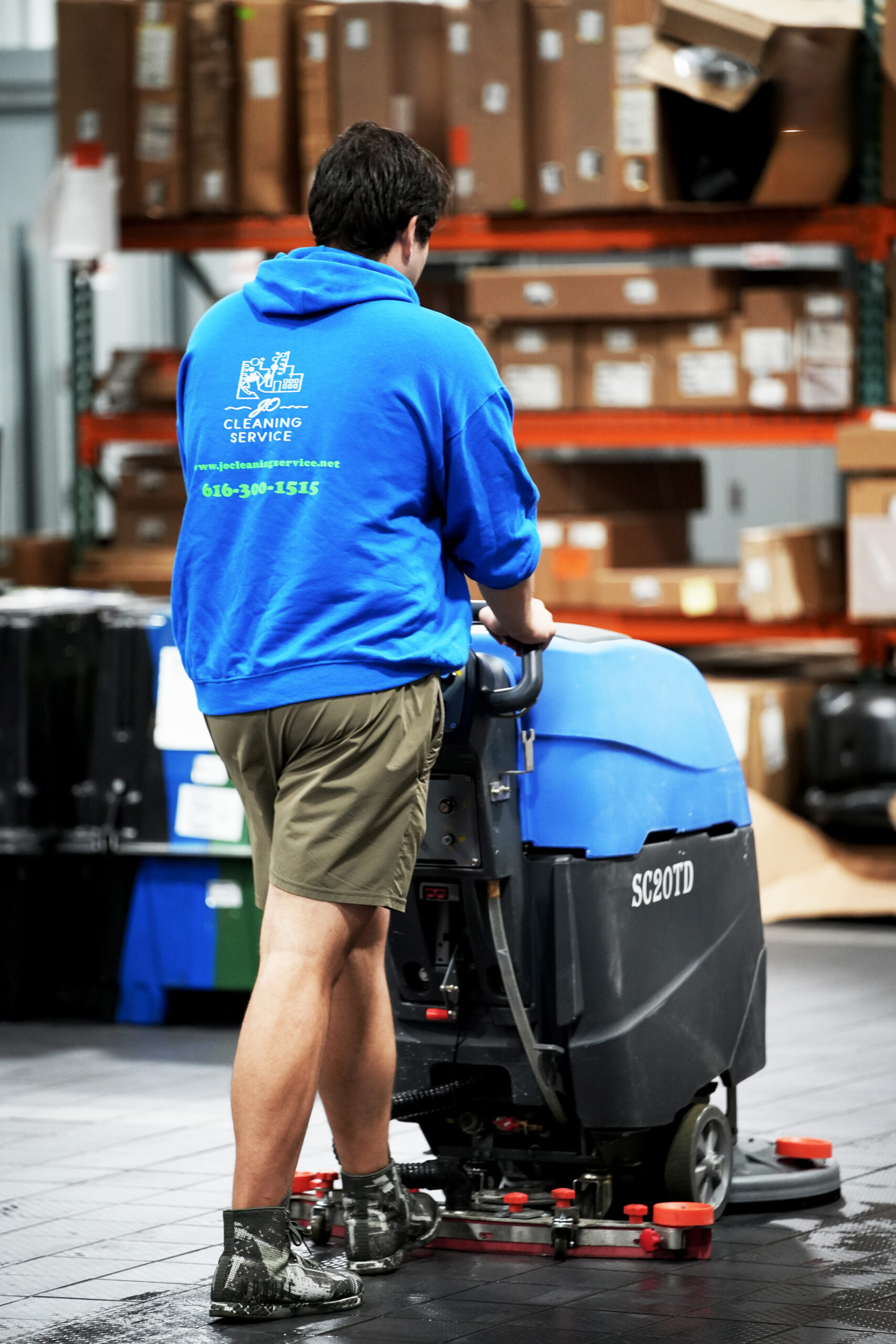 Man in blue shirt cleaning industrial floors