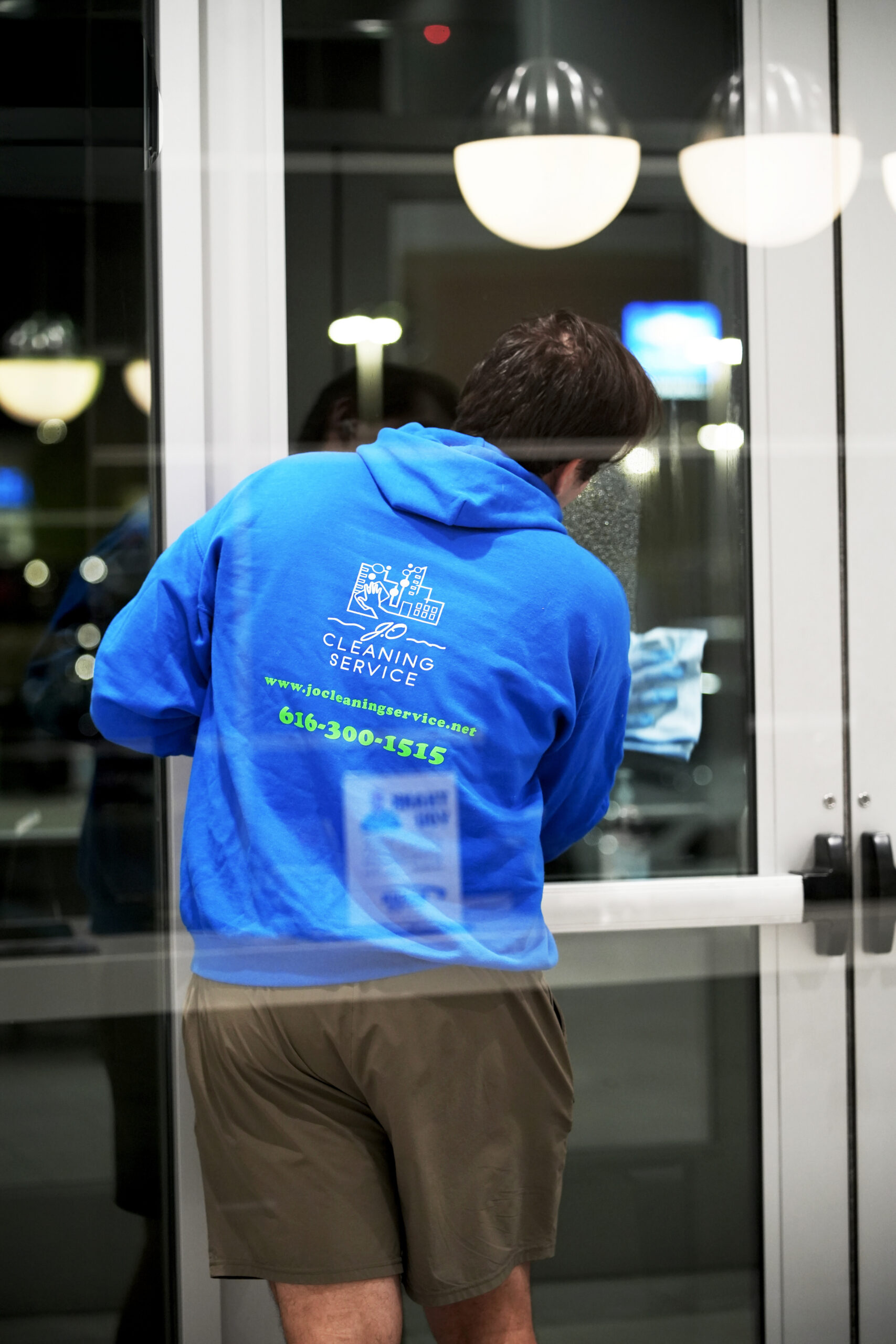 Man in blue shirt wiping glass with blue towel