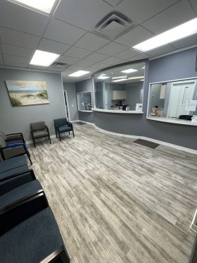 Waiting room with reception window across from chairs